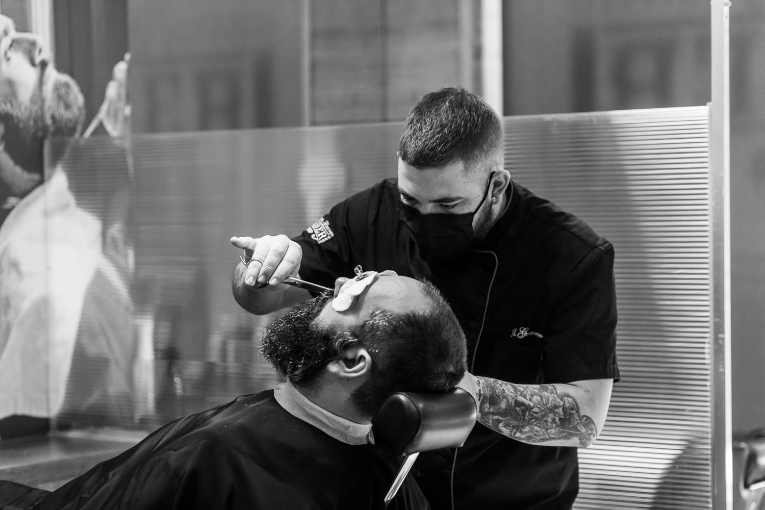 Barbero arreglando la barba a un cliente